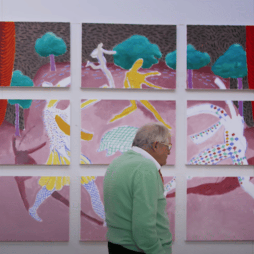 Older gentleman walking past a canvas wall in a museum