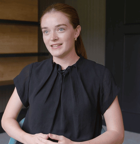 Woman in black top with a ponytail looking off to the side