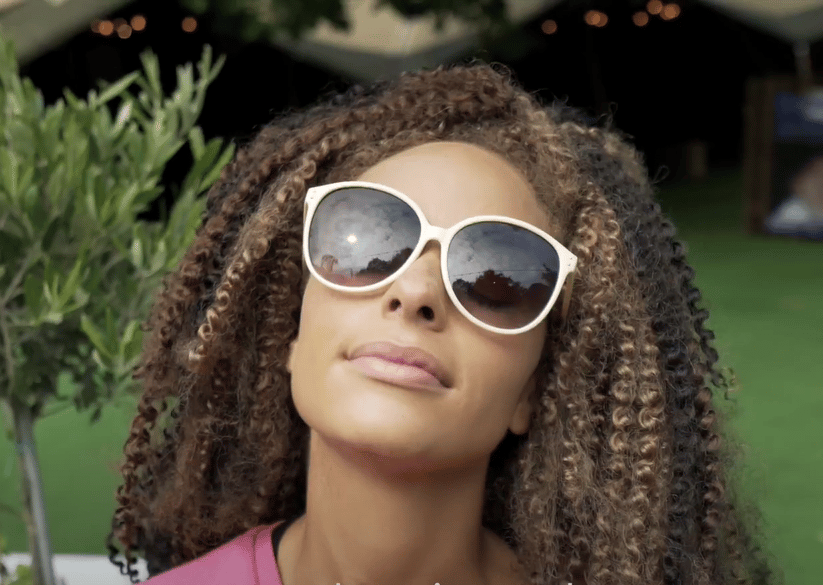 Woman wearing large white sunglasses and looking at the sky