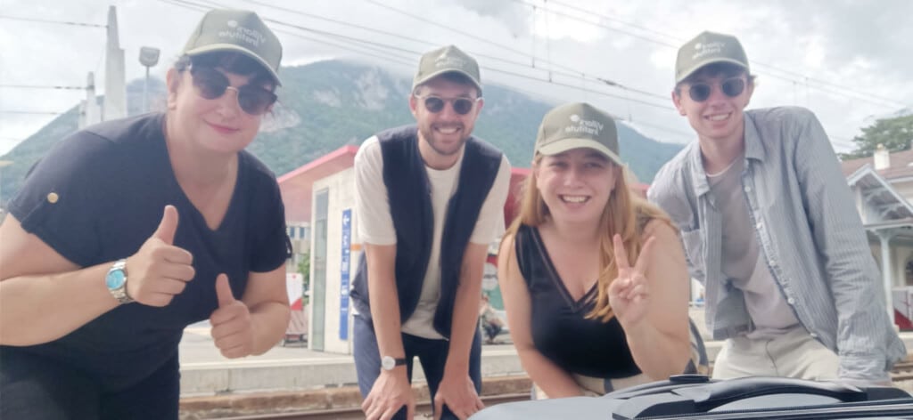 Group of people in matching hats smiling and posing for the camera