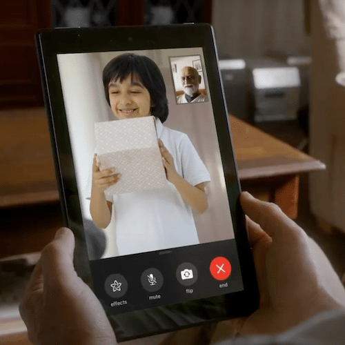A boy with a present smiles on a video call